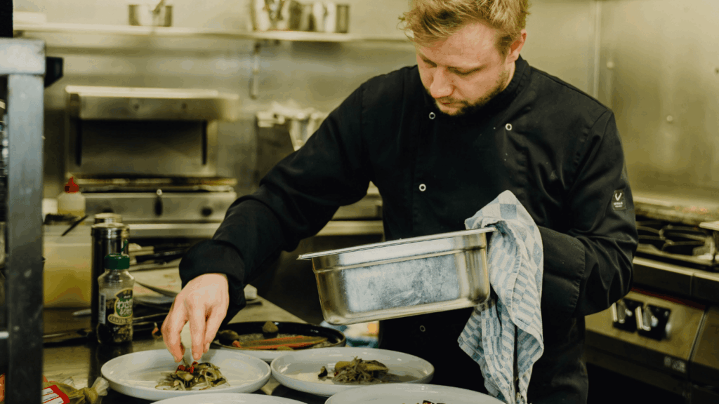 Cook prepares dishes in the kitchen